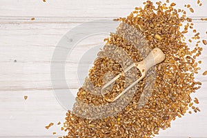 Raw bulgur grains on grey wood