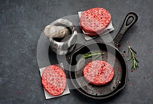 Raw burgers cutlets from beef meat with with pepper and rosemary