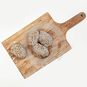 Raw burgers cutlets from organic beef meat on wooden cutting board isolated on white