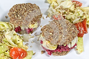 Raw burgers and salad on a white background