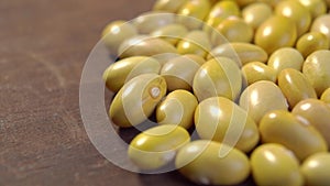 Raw Canary peruvian yellow beans. Dry peruano legumes on rustic wooden surface. Macro.