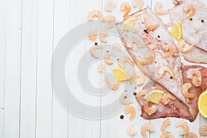 Raw carcass of squid and shrimp with spices and lemon is ready for cooking on the table