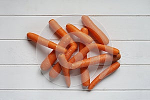 Raw carrots on white wooden table