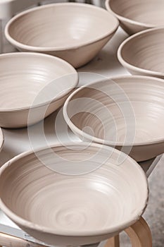 Raw ceramic bowls made from white clay on the potter`s wheel circle waiting for putting in the pottery kiln, concept of creativit