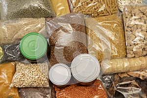 Raw cereals, jars of marinades, pasta, bags of porridge and grains on the table.