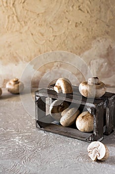 Raw champignons on a rustic wooden box