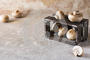 Raw champignons on a rustic wooden box