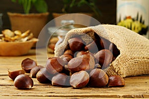 Raw Chestnuts background on rustic wooden table photo