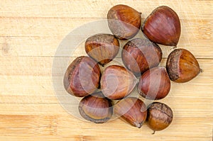 Raw chestnuts on a wooden background. Oleaginous