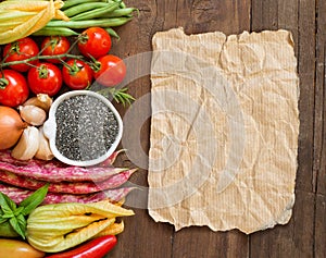 Raw chia seeds in a bowl and fresh vegetables