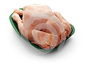 Raw chicken body in a green tray over white background