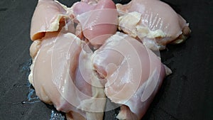 Raw chicken breast chunks on a clean black kitchen surface