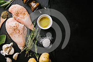 Raw chicken breast on dark background