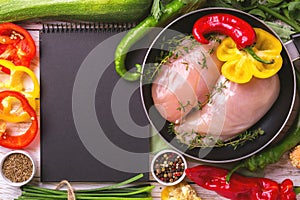 Raw chicken breast fillets with vegetables ingredients in pan