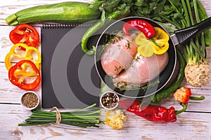 Raw chicken breast fillets with vegetables ingredients in pan