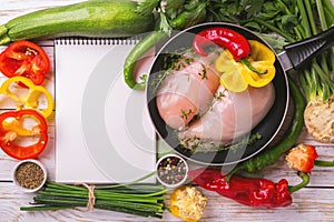 Raw chicken breast fillets with vegetables ingredients in pan