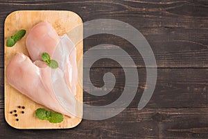 Raw chicken breast fillets on wooden background with a lot of co