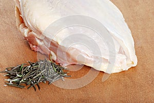 Raw chicken breast with fresh rosemary