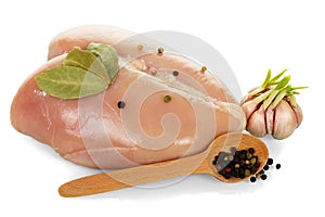 Raw chicken breast, garlic and black pepper in spoon isolated