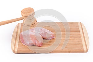 Raw chicken breast and mallet