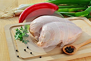 Raw chicken breast with skin and vegetables