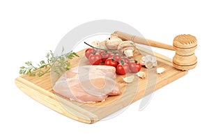 Raw chicken breast with tomatoes and mushrooms.