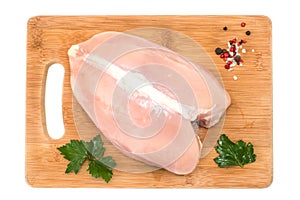 Raw chicken Breasts and spices on wood chopping Board isolated on white