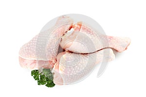 Raw chicken drumsticks with parsley on white, top view. Fresh meat