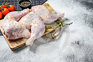 Raw chicken drumsticks with thighs, fresh herbs, cooking. Gray background. Top view. Copy space