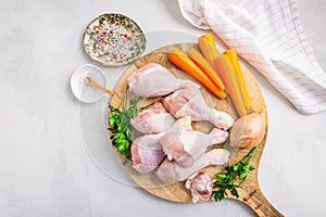 Raw chicken drumsticks with vegetables ans spices prepared for cooking photo