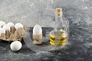 Raw chicken egg in eggcup with eggbox on a marble background