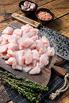 Raw chicken fillet cut into cubes, Uncooked sliced poultry meat, on wooden board. Wooden background. Top view