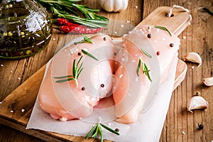 Raw chicken fillet with garlic, pepper, olive oil and rosemary