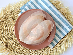 raw chicken fillets on wooden cutting board, top view