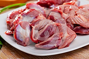 Raw chicken gizzards on wooden table