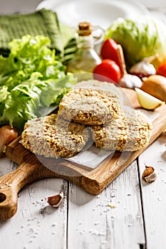 Raw chicken hamburger cutlet breaded with paprika and garlic. Homemade minced poultry cutlet with spices. Fresh lettuce leaves