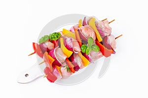 Raw chicken leg meat skewers with vegetables,peppers, onions,white background.Uncooked mixed meat skewer with peppers