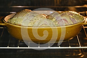 Raw chicken leg thigh in an oven bowl, cooking process