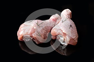 Raw chicken legs on black background