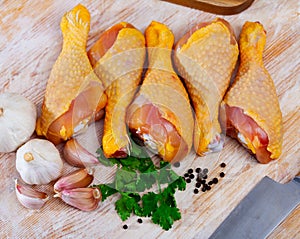 Raw chicken legs on cutting board and plate