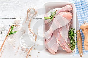 Raw chicken legs, fresh poultry drumsticks on white wooden table
