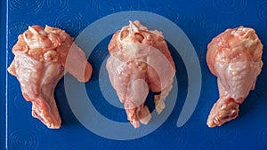 Raw chicken legs on a tray in blue,top view.