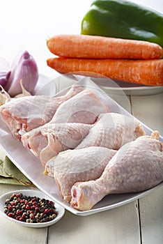 Raw chicken legs with vegetables for cooking