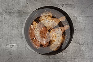 Raw chicken meat in marinade in frying pan ready for cooking