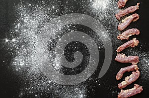 Raw chicken necks on a black with white background