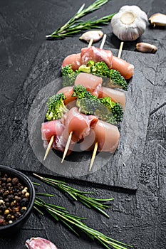 Raw chicken shish kebab with broccoli, Barbecue. Black background. Top view