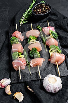 Raw chicken shish kebab with broccoli, Barbecue. Black background. Top view