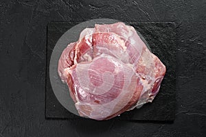 Raw chicken thigh fillet. Farm eco meat. Dark  background. Top view