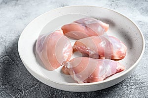 Raw chicken thigh fillet. Gray background. Top view