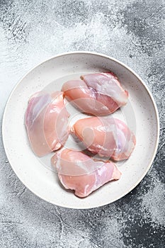 Raw chicken thigh fillet. Gray background. Top view